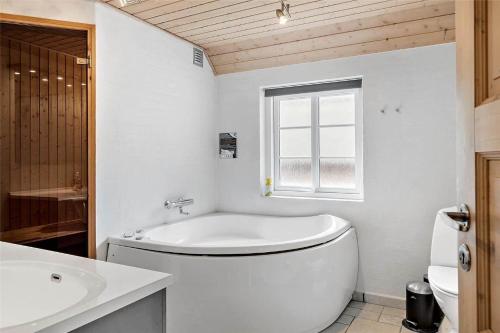 a white bathroom with a toilet and a sink at 10878-Ulfborg-Graemvej-31 in Ulfborg
