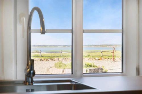 a kitchen sink with a window looking out at the beach at 20033-Ulfborg-Vesterhavsvej-15 in Ulfborg
