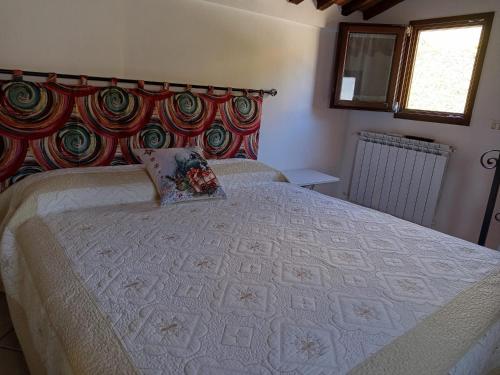a bedroom with a large bed with a pillow on it at Casina Luce in Stiava