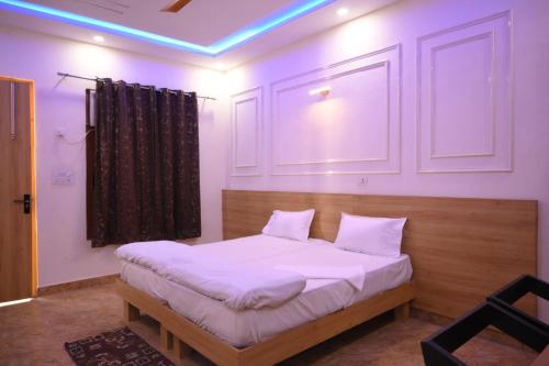 a bedroom with a bed with white sheets at SHIVAAY GARDEN in Kannauj