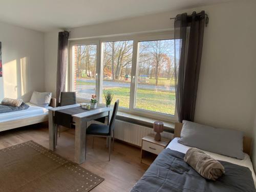 a bedroom with a bed and a table and a window at Ferienwohnung Neumann in Lentföhrden