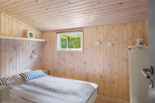 a small bedroom with a bed and a window at 30394-Ulfborg-Kaprifolievej-8 in Ulfborg