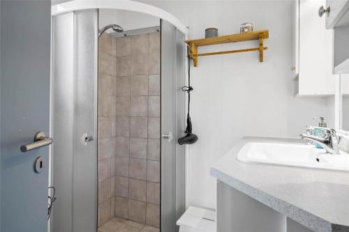 a white bathroom with a shower and a sink at 30394-Ulfborg-Kaprifolievej-8 in Ulfborg