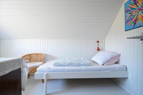 a small bedroom with a bed and a chair at 20261-Ulfborg-Vederso-Klitvej-20 in Ulfborg