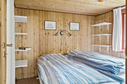 a bedroom with a bed in a wooden wall at 30065-Ulfborg-Oster-skovvej-63 in Ulfborg