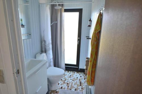 a bathroom with a white toilet and a window at 20356-Ulfborg-Lars-Murersvej-9 in Ulfborg