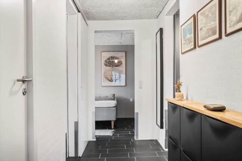 a hallway with white walls and black tile floors at 70222-Ulfborg-Jagtvejen-8 in Ulfborg