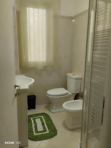 a white bathroom with a toilet and a sink at Casa Doppia G in Oliveri