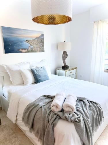 a bedroom with a white bed with towels on it at Penthouse over Monaco in Beausoleil