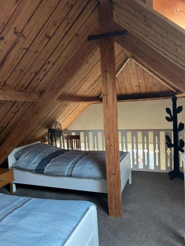 a bed in a room with a wooden ceiling at Familie- en Groepsverblijf Het Voorhuis in Loon op Zand