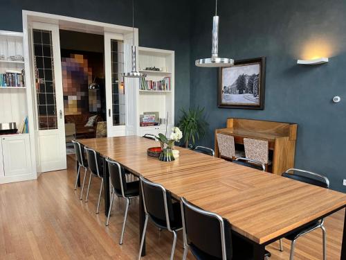 a dining room with a large wooden table and chairs at Familie- en Groepsverblijf Het Voorhuis in Loon op Zand