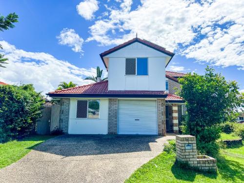 a white house with a red roof at Vista Air conditioned Holiday Dream Castle Youth Hotel in Brisbane