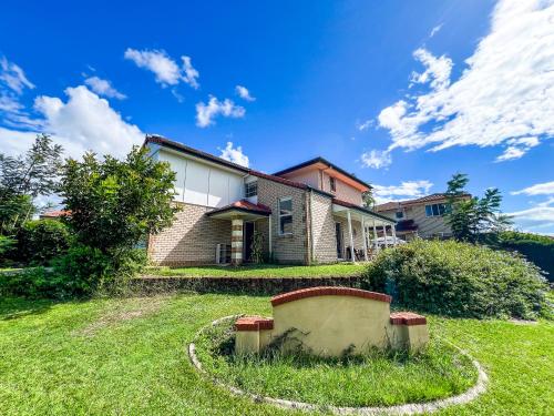 a house on a hill with a grassy yard at Vista Air conditioned Holiday Dream Castle Youth Hotel in Brisbane