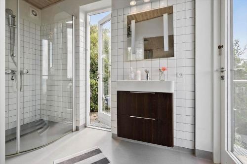 a bathroom with a sink and a shower and a mirror at SL324-Slagelse-Strandvaenget-29 in Slagelse