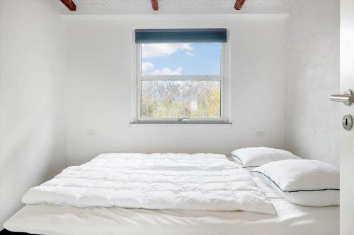 a bed in a white room with a window at SL301-Korsor-Strandengen-1 in Korsør