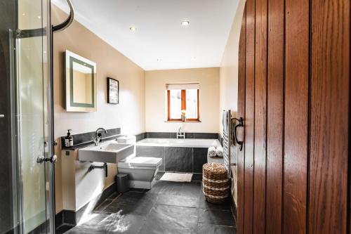 a bathroom with a sink and a bath tub at New House Barn in Ashbourne