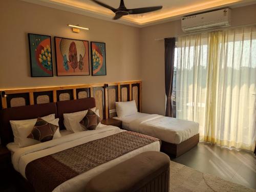 a hotel room with two beds and a window at Aarush Hotel & Resort in Haldwāni