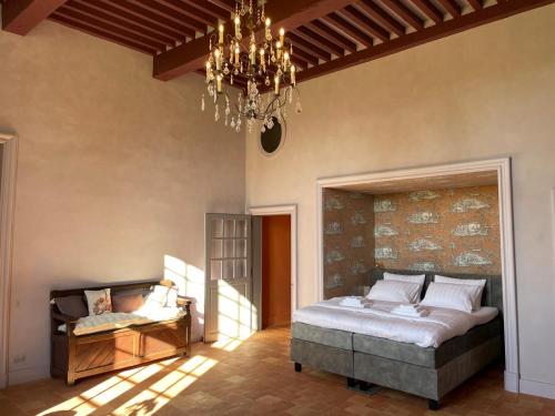 a bedroom with a large bed and a chandelier at Château d'Arcamont in Roquelaure