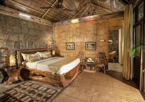 a bedroom with a bed in a room with wooden walls at Bamaeri Royal Resort in Nongpoh