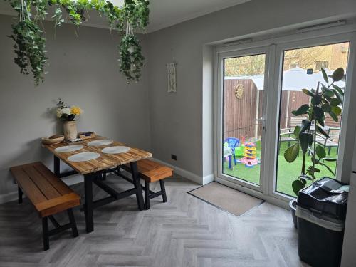 a dining room with a table and a sliding glass door at Alross Guest House with Italian Breakfast in London