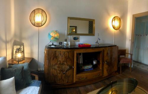 a living room with a large wooden entertainment center at La Ptite Fabrique chez Malot in Montceau-les-Mines
