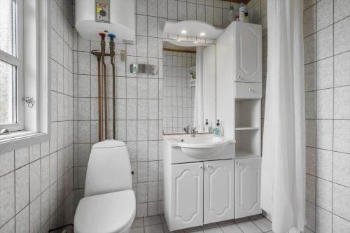 a white bathroom with a toilet and a sink at SL325-Slagelse-Ringduevej-6 in Slagelse