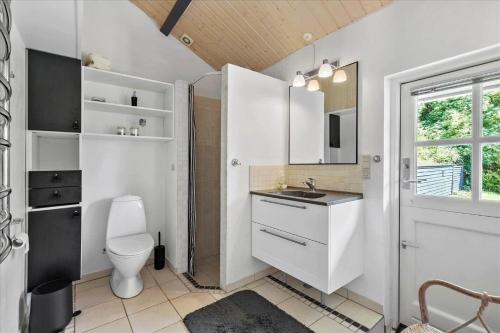 a white bathroom with a toilet and a sink at SL216-Slagelse-Bildsovej-117 in Slagelse
