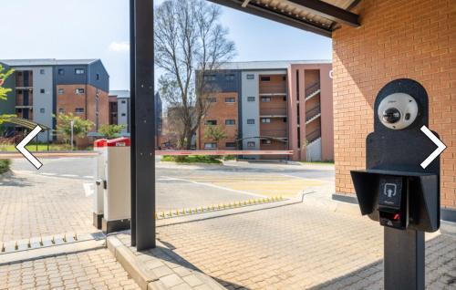 a parking meter with a face on it next to a building at Private Room in a 2-Bed Apartment Shared in Farmall