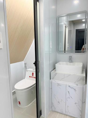 a bathroom with a toilet and a sink and a mirror at Uniton Zen Garden in Ấp Bến Cầu