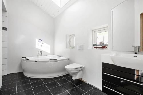 a bathroom with a tub and a toilet and a sink at SL245-Rude-Fuglevaenget-20 in Rude