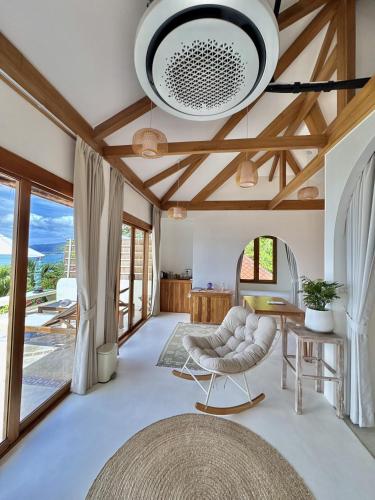 a living room with a vaulted ceiling and a table and chair at Soul Villas Phuket Beachfront Private Pool Villas in Panwa Beach