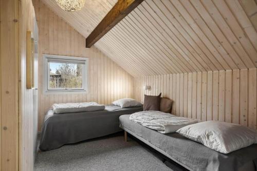 two beds in a room with wooden walls at K20063-Store-Fuglede-Ostvej-6 in Store Fuglede