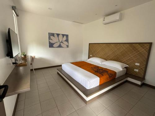a bedroom with a bed and a flat screen tv at Onda Resort Pacifico in San Isidro