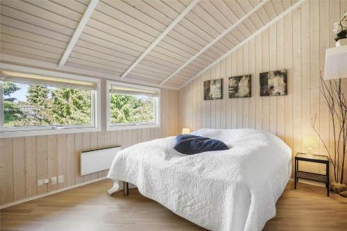 a bedroom with a bed and two windows at SL256-Skaelskor-Ostre-Strand-115 in Skælskør