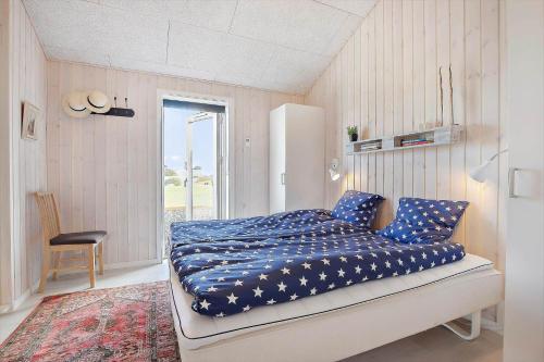 a bedroom with a bed with a blue comforter at SL296-Slagelse-Athenesvej-7 in Slagelse