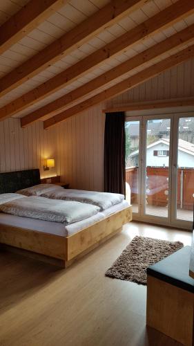 ein Schlafzimmer mit einem großen Bett und einem großen Fenster in der Unterkunft Jani's Holiday Apartment in Interlaken