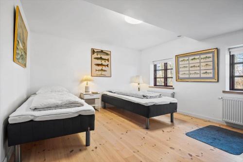 two beds in a white room with wooden floors at SL341-Skaelskor-Glaenovej-140 in Skælskør
