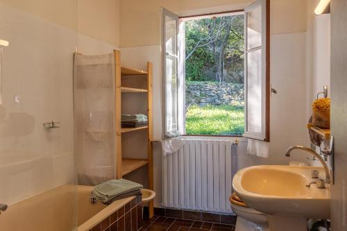 a bathroom with a sink and a toilet and a window at Villa MARION bord de mer in Pino