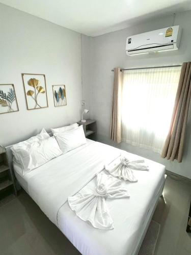 a bedroom with a white bed with flowers on it at Yada House s&s in Nai Yang Beach