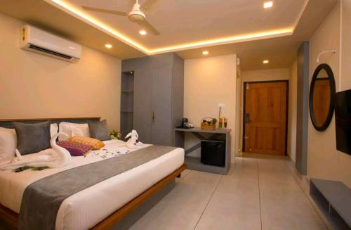 a bedroom with a bed with two swans on it at Amrezy Luxury Resort and Spa, Wayanad in Vythiri