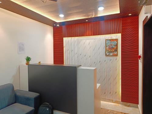 a waiting room with a blue chair and a wall at Hotel Assi Retreat in Varanasi