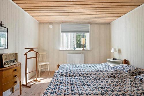 a bedroom with a bed and a tv and a window at KAL159-Gullaskruv-Hetalaga-111 in Gullaskruv