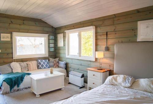 a room with wooden walls and a bed and a couch at STO703-Graeddoe-Maroe-77 in Gräddö