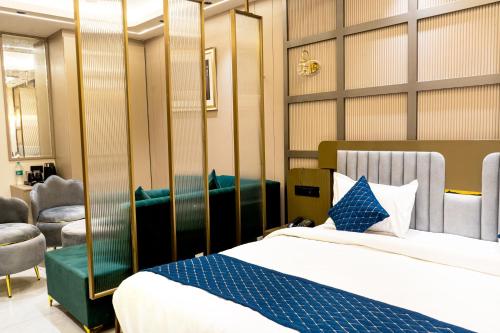 a bedroom with a bed and chairs in a room at Hotel Panipat Prime in Pānīpat