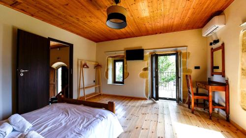 a bedroom with a bed and a wooden ceiling at Villa Andrianna in Frés