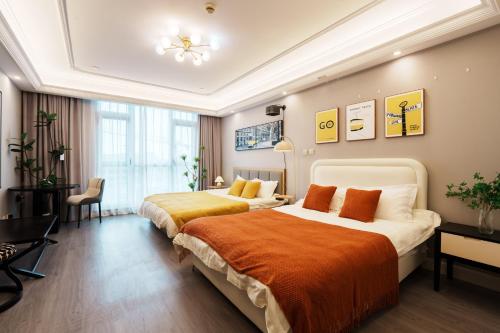 a hotel room with two beds and a desk at Shanghai Little 8 Apartment in Shanghai
