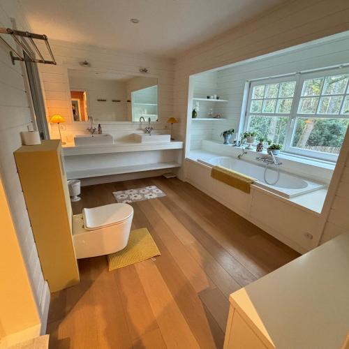 a large bathroom with two sinks and a tub at A Calm & Quiet Stay in Wuustwezel