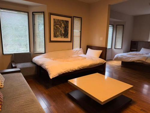 a living room with two beds and a couch at Izu Plateau House 420 square meters, BBQ , 8 bedrooms, 1 living room 1kitchen 6 toilets 4 bathroom 1 onsen in Yawatano