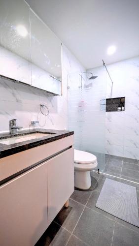 a white bathroom with a toilet and a sink at Cozy Clark Stay 3BR Condo in Clark