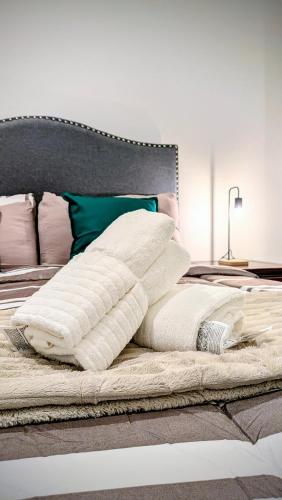 a pile of pillows sitting on top of a bed at Cozy Clark Stay 3BR Condo in Clark